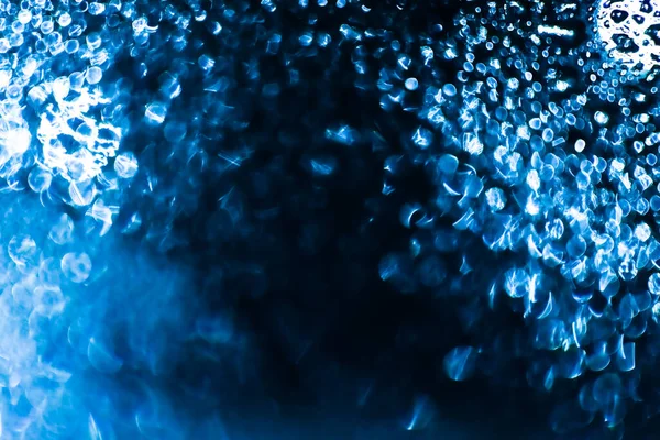 Gotas de agua y gotas de hielo en el fondo azul desenfocado. —  Fotos de Stock