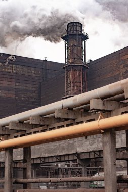 Kalın duman boru fabrikasından dökülüyor..