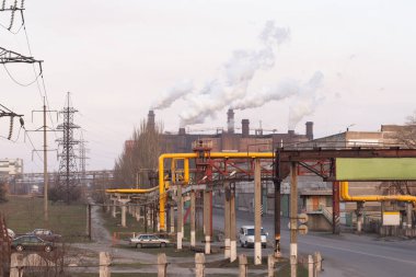 Büyük bir endüstriyel komplekste baca dumanı. yüksek voltajlı elektrik hatları ve üretim atölyeleri. 