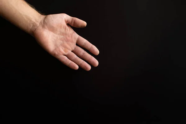 Eine Herrenhand auf schwarzem Hintergrund. — Stockfoto