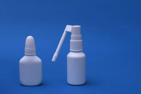 Nasal spray and throat spray on a blue background. space for writing