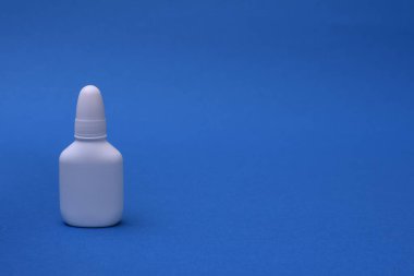 Mavi arka planda burun spreyi. Yazmak için boşluk