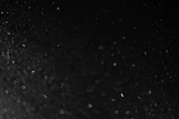 Gotas de água e gelo no vidro sobre um fundo preto. Textura abstrata fundo bokeh escuro com espaço de cópia. Desfocagem. — Fotografia de Stock