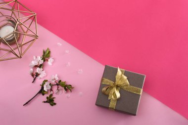 Bir hediye kutusu, çiçek açan bir ağaç dalı, bir mum. Üst görünüm