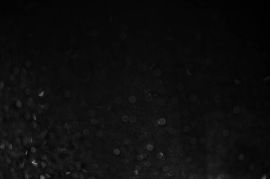 Siyah zemin camında yağmur. Bokeh 'in geçmişinde. Siyah beyaz foto.