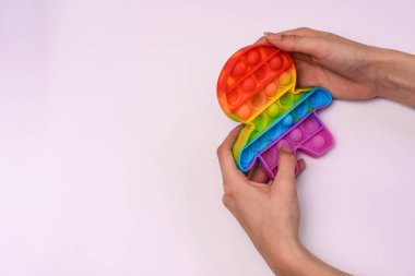 Stres önleyici bir oyuncakla oynuyor. Parmaklar onu patlatmak için sensöre basıyor. Boşluğu kopyala