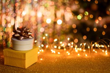 Altın renkli arka planda iki hediye kutusu.. 