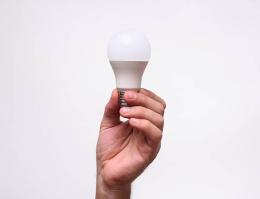 Adam Led Lambası 'nı elinde tutuyor. Çevre lambası, yeşil teknolojiler. 
