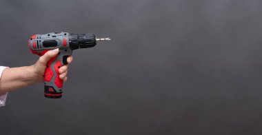 Genişletilmiş kol şeklinde kablosuz matkap, metalik bir parça görünür, kırmızı ve siyah bir alet, DIY için izole edilmiş. Uzatılmış kablosuz matkap kısa bit, güç aracı izole