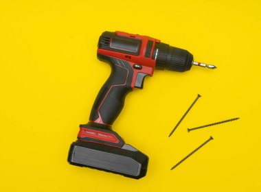 Profesyonel elektrikli alet, güneşli sarı arka planda izole edilmiş. Arkaplanda kablosuz tornavida, siyah kauçuk tutamaktır. Profesyonel iş için modern kablosuz tornavida ve aksesuarlar