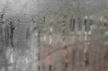 Nemli şeffaf cam yüzeydeki damlacıkların soyut görüntüsü. Atmosferik görseller, arka planlar veya duygusal hikaye anlatımı için uygundur..