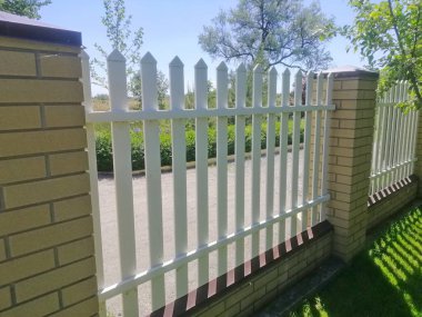 Beyaz modern çitler, temiz geometrik çizgilerle özel mülkü tanımlar. Açık hava mekanları için minimalist estetik bir güvenlik tasarımı. Kır evinde güvenilir mahremiyet çiti 