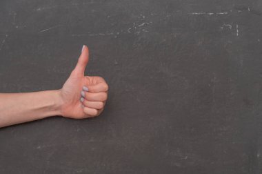 Koyu arkaplanda el hareketi, onay ya da başarıyı ifade eden el işareti, olumlu geri bildirim konsepti için kullanılan el hareketi. İnsan eli işaret veriyor..