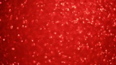 Kırmızı parıldayan parıltı yumuşak parıltılar, parlayan yüzey. Hareket ışığı yansımaları soyut şenlik havası oluşturur. Işıldayan kırmızı parıltı dokusu yumuşak odak noktasında parlar. lüks atmosfer ve tatil enerjisi.