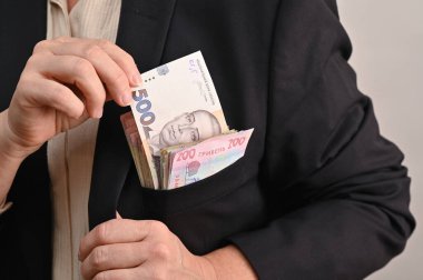 Adamın ceketinin cebinde bir yığın banknot var. Cebinde Ukrayna Hryvnia 'sı var. Nakit para. Kadın cebinden 500 Hryvnia banknotu çıkardı..