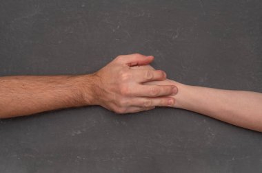 Çatışma, birbirine tutunan kadın ve erkeğin ellerinden çıktı. Gerilim ve mücadele. Muhalefetin karşı eylem sembolü, yakın çekim detayı, insan ilişkileri konsepti, erkek ve kadın elleri