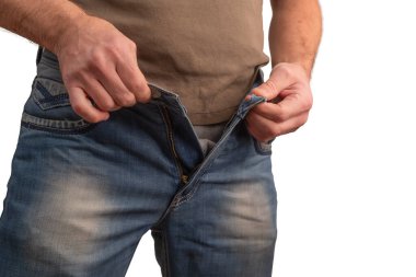 Erkek eller beyaz arka planda izole edilmiş açık kot fermuarı ayarlıyor. Denim pantolonun yakın çekimi fermuar ve kumaş dokusunu gösteriyor. Yaşam tarzı ve moda konsepti giysi detaylarına odaklanmış, gündelik modern kıyafetler.