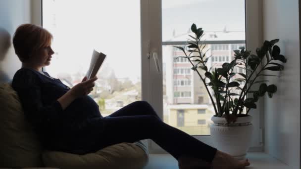 Mujer embarazada cerca de la ventana — Vídeos de Stock