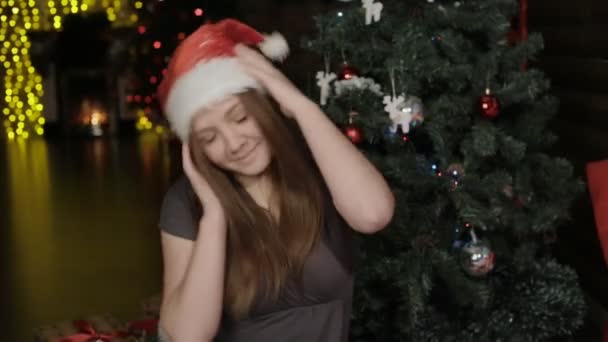 Feliz chica joven en una gorra roja de Navidad — Vídeos de Stock