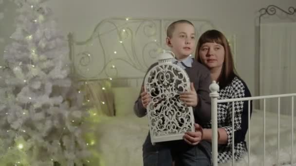 Mère et fils assis sur le lit dans un intérieur du Nouvel An — Video