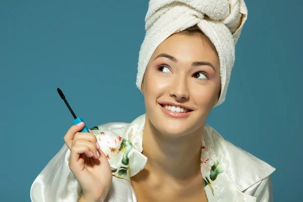 Jong Aantrekkelijk Vrouw Zetten Oog Mascara Blauwe Achtergrond Schoonheid Behandeling — Stockfoto