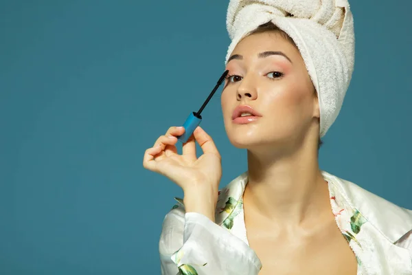 Young Attractive Woman Putting Eye Mascara Blue Background Beauty Treatment — Stock Photo, Image