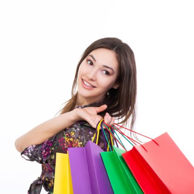 Renkli alışveriş torbalarıyla beyaz üzerinden alışveriş yapan güzel mutlu bir kız. Mevsimlik satış ve gülümseyen genç kadın