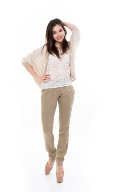 Kameraya bakan, beyaz tenli, çekici, neşeli genç kızın tam boy portresi. Genç mutlu moda bej renkli moda kıyafetler.