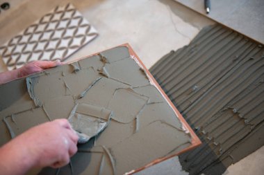 Tiler seramik fayansı yere seriyor. Profesyonel işçi tadilat yapıyor. İnşaat. Tetler 'in elleri. Ev yenileme ve yeni ev inşa etme