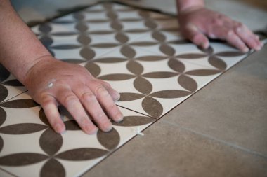 Tiler seramik fayansı yere seriyor. Profesyonel işçi tadilat yapıyor. İnşaat. Tetler 'in elleri. Ev yenileme ve yeni ev inşa etme