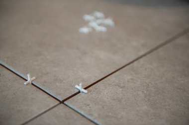 Tiler seramik fayansı yere seriyor. Profesyonel işçi tadilat yapıyor. İnşaat. Tetler 'in elleri. Ev yenileme ve yeni ev inşa etme