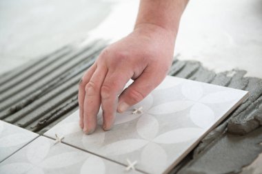 Tiler seramik fayansı yere seriyor. Profesyonel işçi tadilat yapıyor. İnşaat. Tetler 'in elleri. Ev yenileme ve yeni ev inşa etme