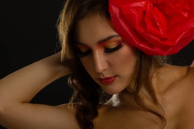 Saçında kırmızı çiçek olan çekici bir kızın klasik portresi. Stüdyo çekimi. İspanyol Carmen tarzı