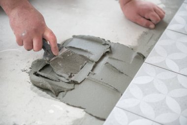 Tiler seramik fayansı yere seriyor. Profesyonel işçi tadilat yapıyor. İnşaat. Tetler 'in elleri. Ev yenileme ve yeni ev inşa etme