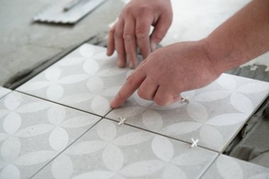 Tiler seramik fayansı yere seriyor. Profesyonel işçi tadilat yapıyor. İnşaat. Tetler 'in elleri. Ev yenileme ve yeni ev inşa etme