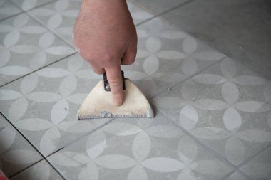 Tiler seramik fayansı yere seriyor. Profesyonel işçi tadilat yapıyor. İnşaat. Tetler 'in elleri. Ev yenileme ve yeni ev inşa etme