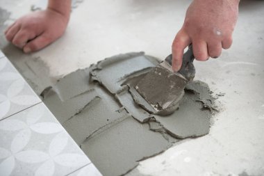 Tiler seramik fayansı yere seriyor. Profesyonel işçi tadilat yapıyor. İnşaat. Tetler 'in elleri. Ev yenileme ve yeni ev inşa etme