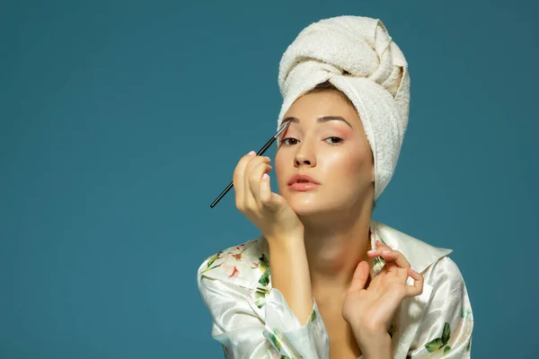 Young Attractive Woman Putting Eye Mascara Blue Background Beauty Treatment — Stock Photo, Image