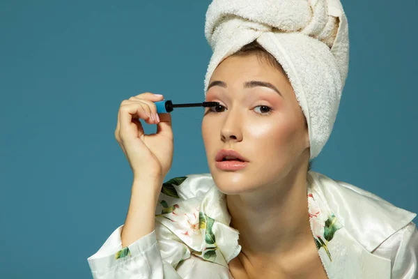 Young Attractive Woman Putting Eye Mascara Blue Background Beauty Treatment — Stock Photo, Image