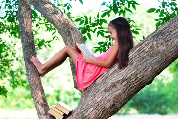 Okouzlující Holčička Dlouhými Hnědými Vlasy Čte Knihu Venkovní Posezení Stromě — Stock fotografie