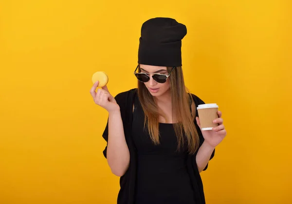 Hipster Menina Come Macaron Bolo Bebe Cogffee Sobre Fundo Amarelo — Fotografia de Stock