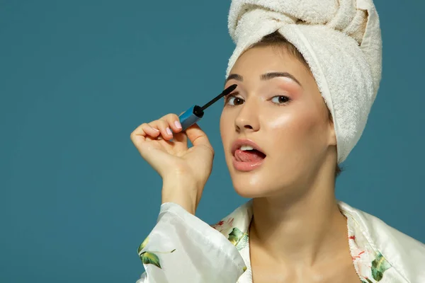 Young Attractive Funny Woman Putting Eye Mascara Studio Shot Blue — Stock Photo, Image