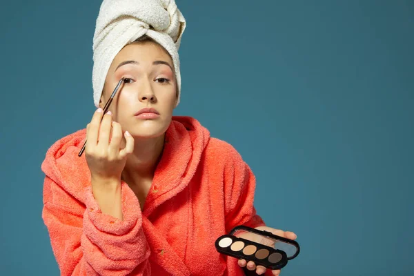 Joven Mujer Hermosa Poniendo Sombras Sus Párpados Sobre Fondo Azul — Foto de Stock