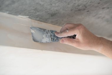 Tamirci sıva tahtasıyla çalışır, kuru taş duvar yapıştırır, ev dekorasyonu yapar. Adam evde tamirat yapıyor.. 