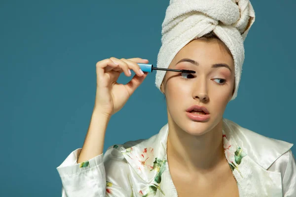 Jonge Aantrekkelijke Grappige Vrouw Zetten Oog Mascara Studio Schot Blauwe — Stockfoto