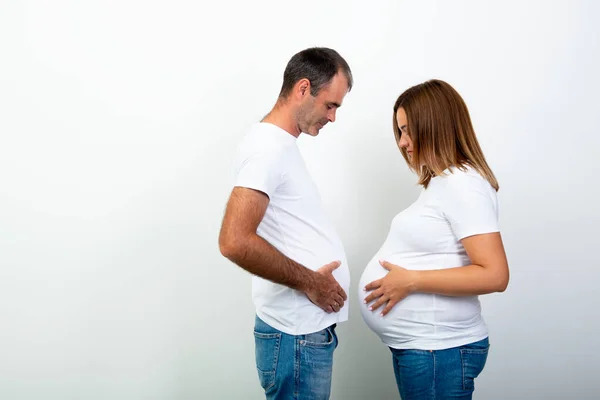 怀孕了幸福的家庭在等着孩子 男人和怀孕的女人是以腹部来衡量的 妻子和丈夫有趣的肖像 夫妻生活方式 — 图库照片