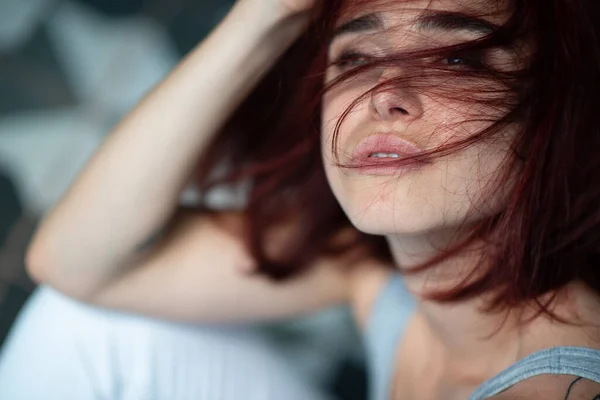 Beautiful young stylish ginger woman with freckles. Fashion portrait of charming girl wearing casual clothes posing at home. Passion