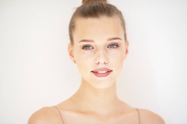 Temiz ciltli güzel bir kadının portresi, gençlik konsepti, güzellik tedavisi. Neşeli genç kız, güzel kadın yüzü mutlu gülümseyen ve beyaz arka planda kameraya bakan