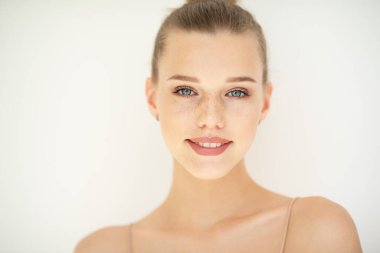 Temiz ciltli güzel bir kadının portresi, gençlik konsepti, güzellik tedavisi. Neşeli genç kız, güzel kadın yüzü mutlu gülümseyen ve beyaz arka planda kameraya bakan