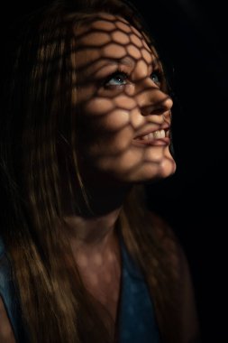 Günah çıkarma odasında güzel bir kadın günah çıkarıyor. Dua eden bir kadın, ilginç bir ip ve gölge desenli güzel bir resim. Günahların bağışlanması. 